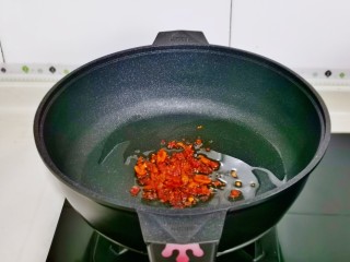 培根芦笋卷,起油锅，加入辣椒粉煸炒。