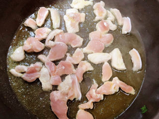 洋葱炒肉片,锅中倒入油，加热至五成热，放入肉片翻炒均匀。