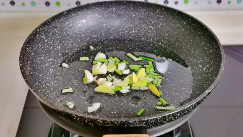 芹菜炒鱿鱼,起油锅加入切好的葱姜蒜煸炒出香味。