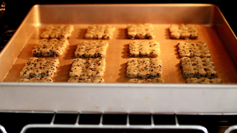 全麦黑芝麻苏打饼干,烤箱提前预热，把烤盘放入烤箱中层，180度烤12分钟即可。