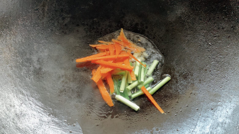 韭菜炒粉丝,同时，也加入胡萝卜丝进入翻炒