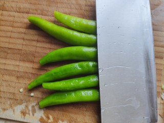 清炒油麦菜,尖椒去蒂去籽，洗净之后用刀背拍几下