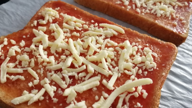 菠萝披萨,撒上适量马苏里拉奶酪碎。