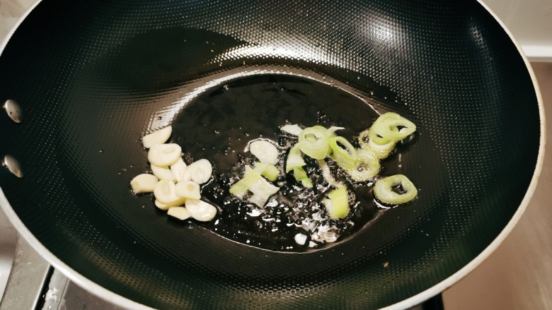 芹菜炒鱿鱼,起油锅放入食用油，油热后放入蒜片葱片炒出香味。