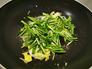 韭菜炒粉丝,先放入韭菜梗部分翻炒。