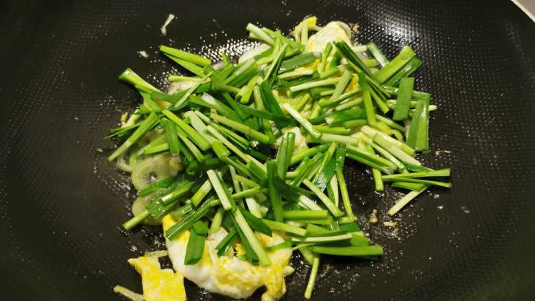 韭菜炒粉丝,先放入韭菜梗部分翻炒。