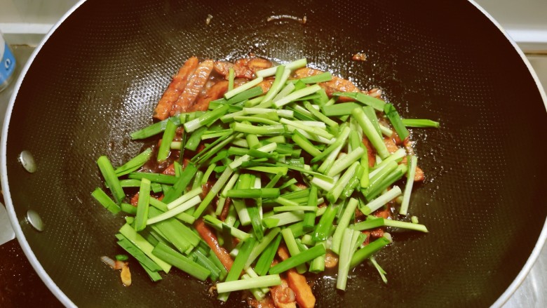 韭菜炒香干,放入韭菜梗部分，翻炒均匀。