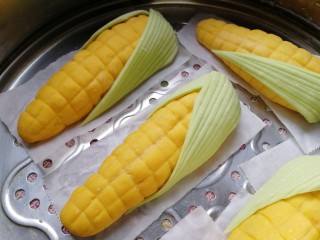 玉米馒头,叶子包裹上玉米，放入蒸锅饧发30分钟，体积变大变轻。