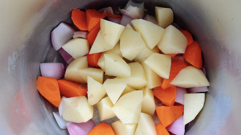 土豆烧肥肠,而后将土豆块、胡萝卜块加入其中待用。