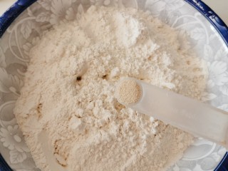 山药小馒头,面粉加入酵母粉拌匀。