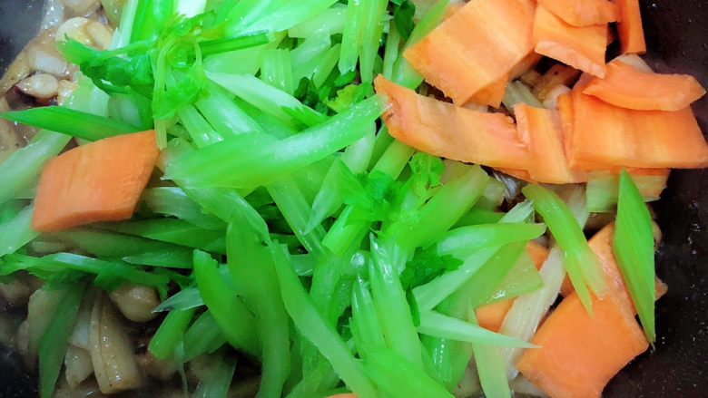 芹菜炒鱿鱼,放入芹菜和胡萝卜翻炒均匀。