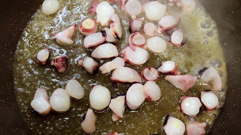芹菜炒鱿鱼,锅中倒入油，加热至五成热，放入鱿鱼爆香。