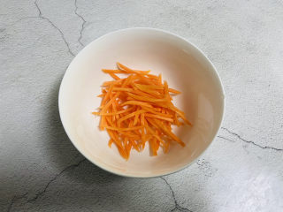 凉拌杏鲍菇,胡萝卜去皮洗净切丝放入碗中