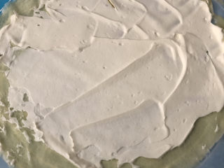 芒果千层蛋糕,烤纸上先平铺一张面皮，涂抹上奶油。