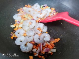 多彩虾仁炒饭,放入葱花，蒜粒，洋葱爆香，放入虾仁，胡萝卜翻炒。