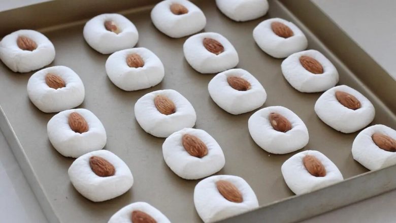 棉花糖饼干,这时棉花糖体积会变大，取出在上面放一颗杏仁，要按压一下哟，让杏仁嵌入棉花糖里。