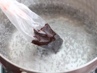 棉花糖饼干,将适量黑巧克力放进裱花袋里，隔水加热至融化状态。