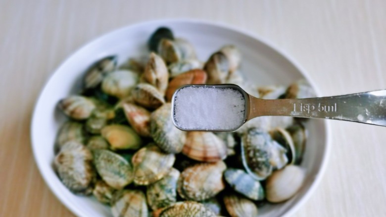 辣炒花甲,洗干净的花蛤放入盘中，按个人口味加入盐。