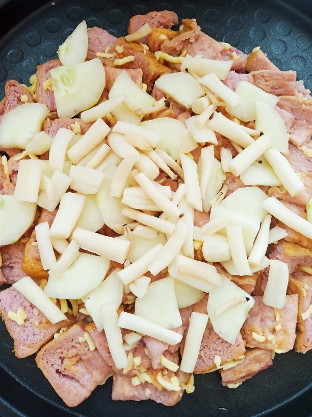 自制简易披萨,均匀的铺上黄瓜片和一部分真姬菇。