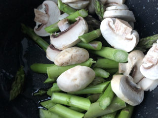 芦笋炒蘑菇,倒入食材。