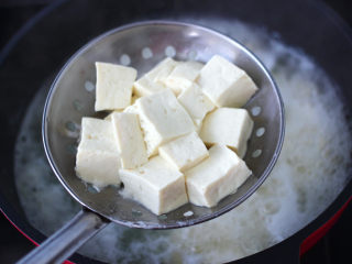 香椿皮蛋豆腐,北豆腐切小块放入锅中焯一下水，这样会去掉豆腐的豆腥味，吃起来口感更佳。