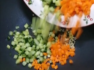 时蔬炒黑米饭,香加入青瓜丁和胡萝卜丁，翻炒片刻