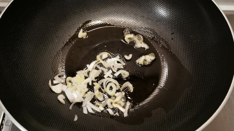 香椿炒腊肉,起油锅放入食用油，油热后放入葱片炒香。