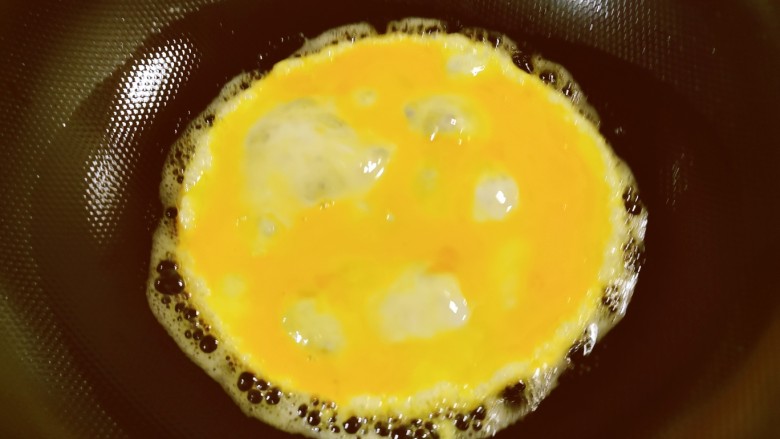 蒜苔炒鸡蛋,油热后放入鸡蛋液。
