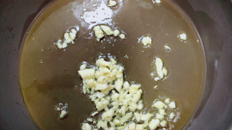 芦笋炒蘑菇,锅中倒入油，加热至五成热，爆香蒜末。