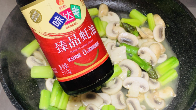 芦笋炒蘑菇,倒入味达美臻品蚝油。