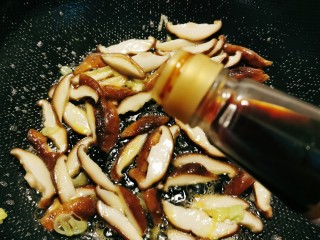 芦笋炒蘑菇,倒入酱油翻炒，倒入50克清水，烧开。