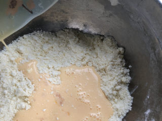 咸蛋黄肉松司康,把牛奶蛋液倒入面粉里。