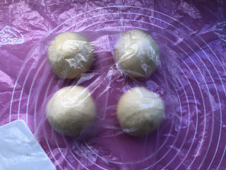 蜜豆毛线球面包,平均分割成4个小面团，盖保鲜膜醒发15分钟。