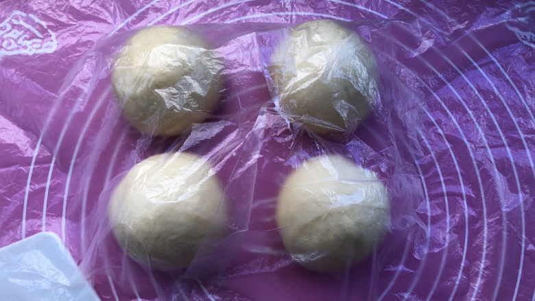 蜜豆毛线球面包,平均分割成4个小面团，盖保鲜膜醒发15分钟。