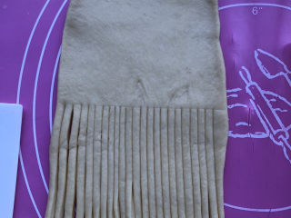 蜜豆毛线球面包,居中切条印记，印记的一边分别均匀地切割成细线条。