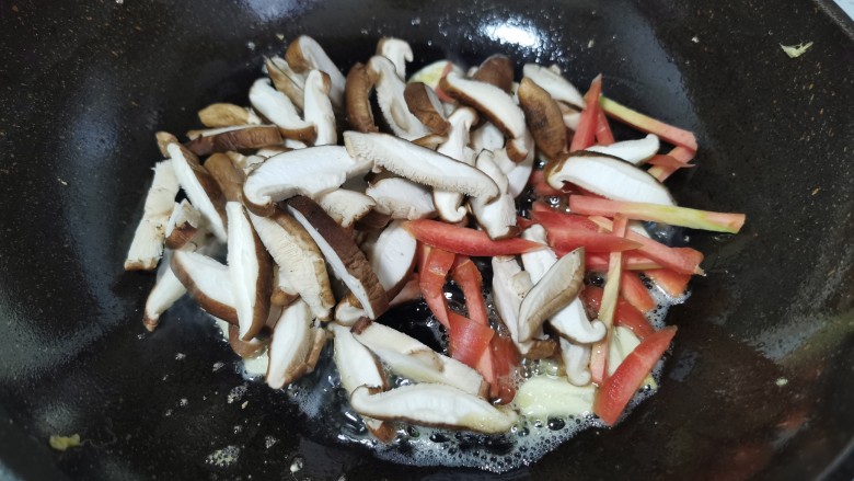 香菇炒鸡蛋,倒入红萝卜和香菇翻炒均匀