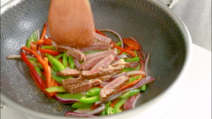 黑椒牛肉意面,加入一勺盐调味，加入牛排条继续翻炒
