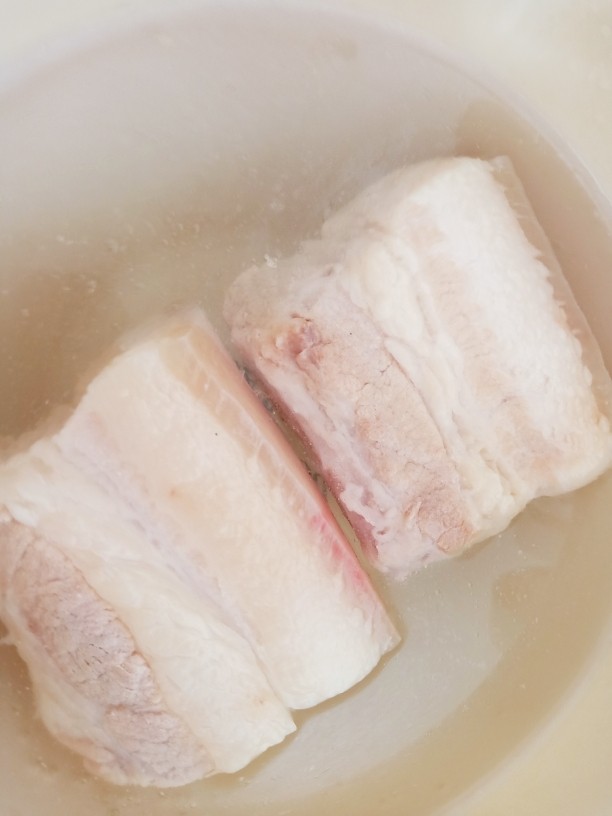 蒜苗回锅肉,煮好的五花肉用冷水浸泡冲洗一下。