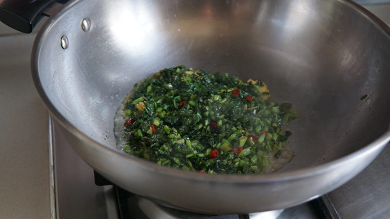 雪菜炒蚕豆,加一汤匙水，盖盖焖至水分蒸发