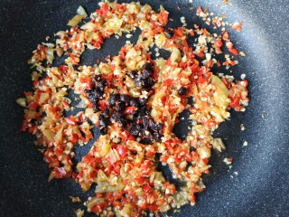 双椒鱼头,再放入小米辣碎泡椒碎和豆豉翻炒均匀。