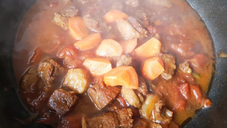西红柿炖牛肉,加盖中小火炖40分钟后加入胡萝卜块，再炖15分钟。