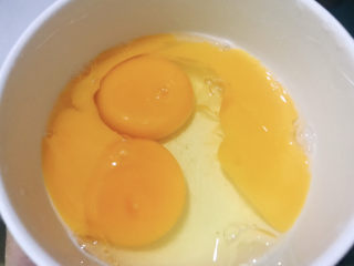 西葫芦炒鸡蛋,碗中磕入两个鸡蛋