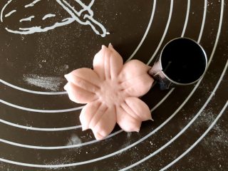 舍不得入口的樱花馒头，美美地开放在餐桌上,再用五角星模具在花瓣顶端切一下，切出一个和樱花花瓣一样的小缺口，这样更有樱花的感觉。