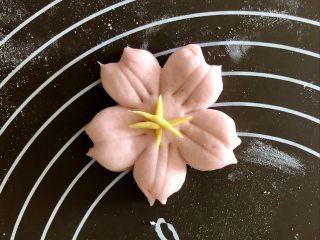 舍不得入口的樱花馒头，美美地开放在餐桌上,把黄色的细条捏成花芯的样子，沾一点水，把花芯粘在樱花中间。