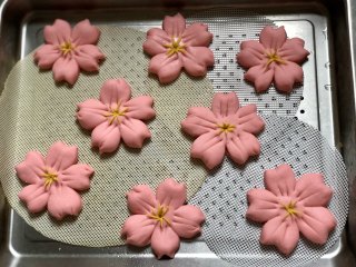 舍不得入口的樱花馒头，美美地开放在餐桌上,所有的樱花馒头做好后，放入蒸盘，推入蒸箱，开始发酵。