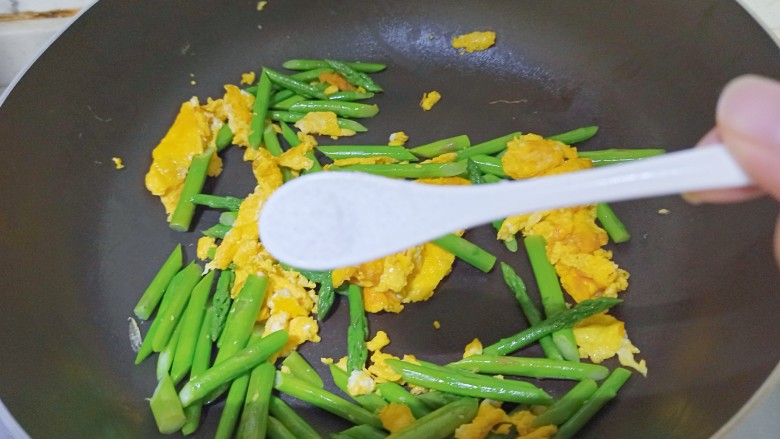 芦笋炒鸡蛋,加入一小勺食盐翻炒均匀