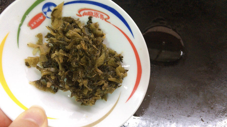 雪菜炒蚕豆,锅烧热油，加入腌制好的雪菜煸炒出香味