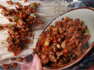 锡纸金针菇,锡纸铺进烤盘里，放上金针菇及炒好的肉末