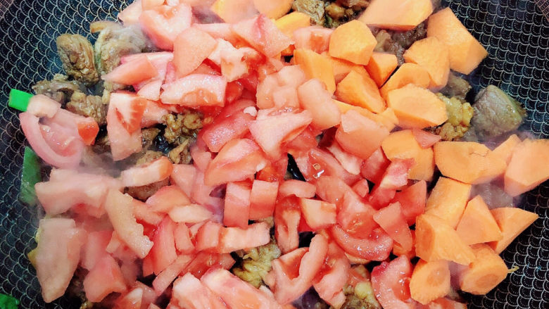 西红柿炖牛肉,放入西红柿、胡萝卜翻炒均匀。