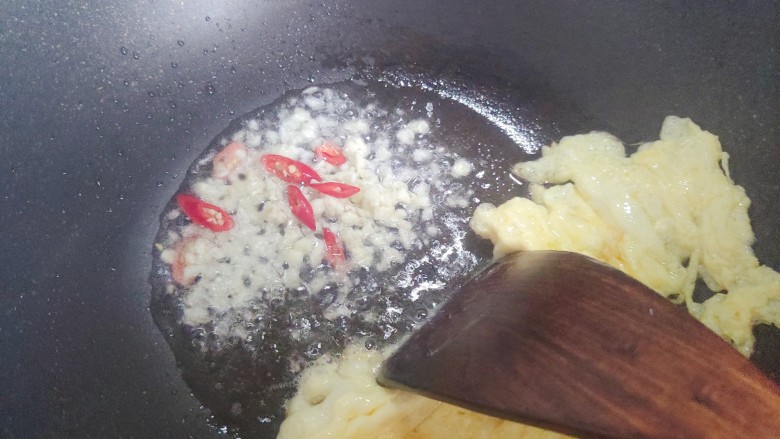 素炒平菇,鸡蛋翻炒凝固结块之后拨到一边，下大蒜末和小米椒，煸香